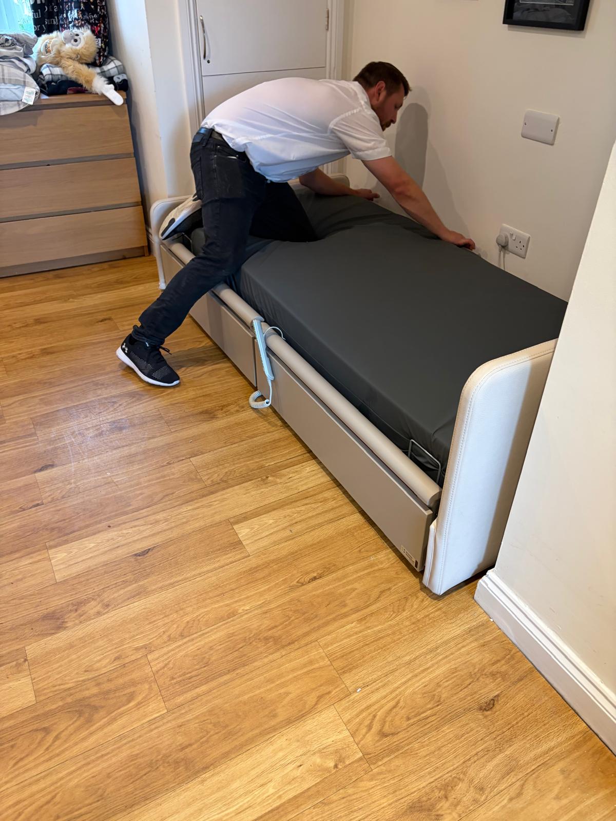 E&M engineer repairing and adjusting a profiling bed in a home