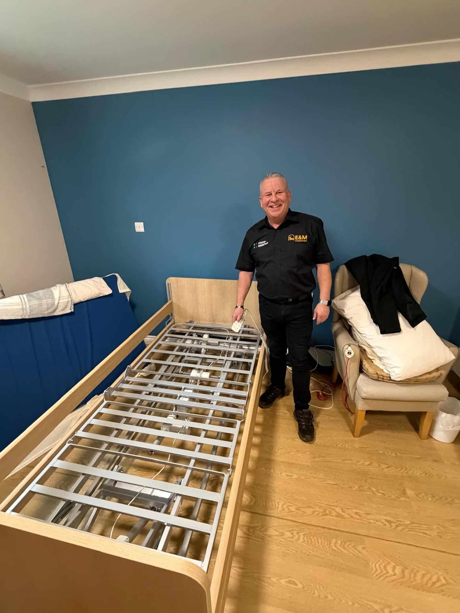 E&M engineer with a profiling care bed during installation